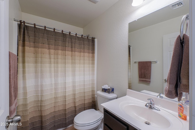 bathroom featuring walk in shower, vanity, and toilet