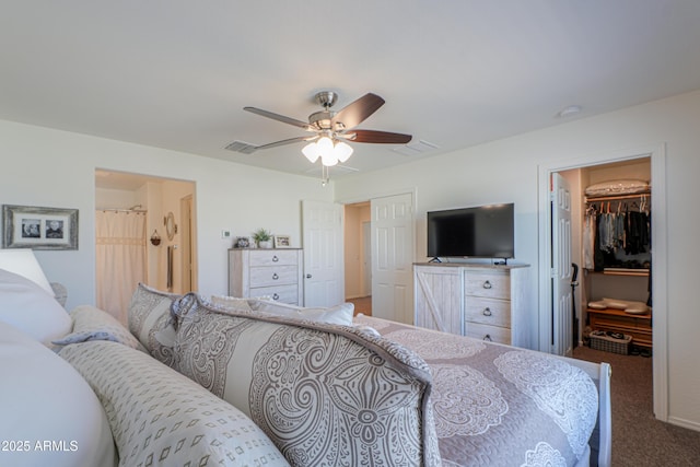 carpeted bedroom with ceiling fan, a spacious closet, and a closet