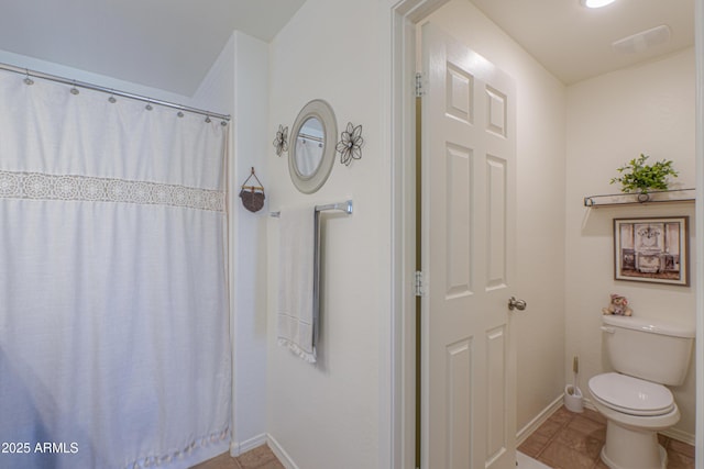 bathroom with toilet and tile patterned floors