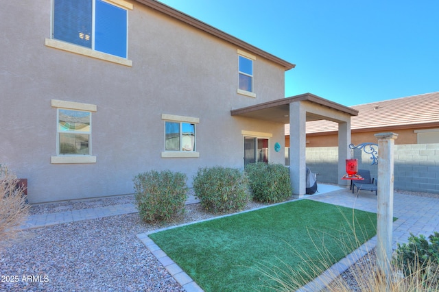 back of property with a patio and a yard