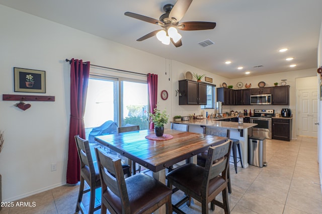 tiled dining space featuring ceiling fan