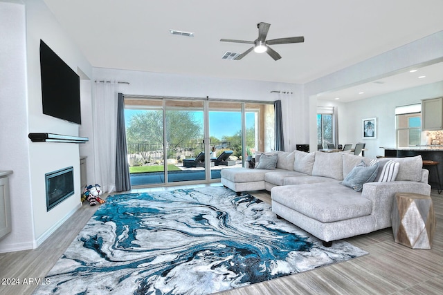 living room with light hardwood / wood-style floors and ceiling fan