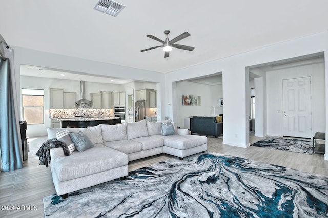 living room featuring light wood-type flooring and ceiling fan