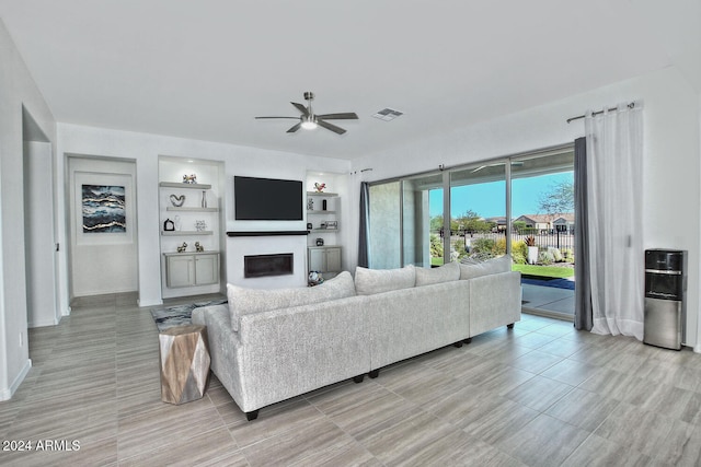 living room featuring ceiling fan and built in features