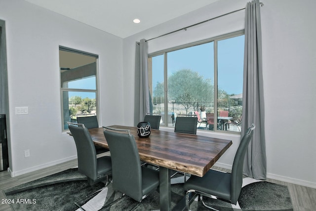 dining space with hardwood / wood-style floors and a healthy amount of sunlight