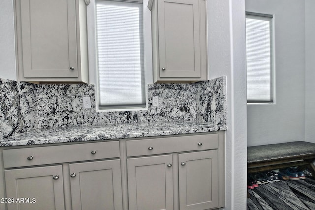 kitchen with a wealth of natural light, gray cabinetry, and backsplash