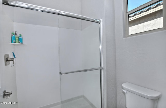 bathroom featuring toilet and an enclosed shower