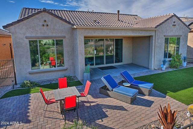 back of property featuring a yard and a patio area