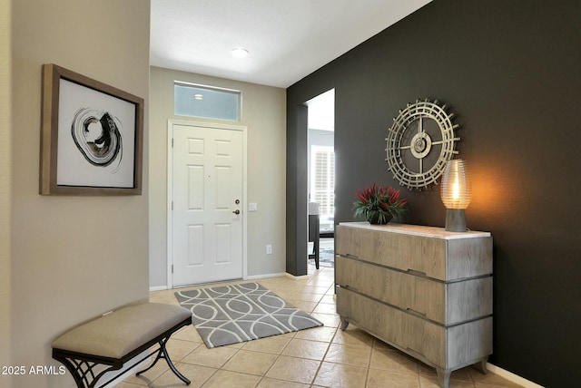 entryway with light tile patterned flooring and baseboards