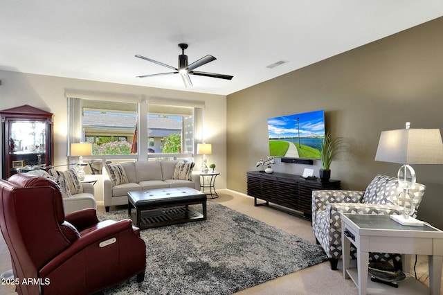 living area with baseboards, visible vents, a ceiling fan, and carpet flooring