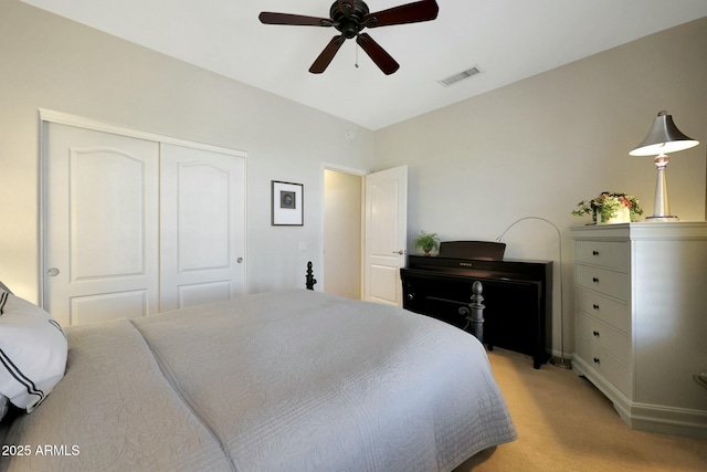 bedroom featuring light carpet, a closet, visible vents, and a ceiling fan