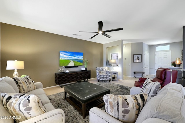 living area with light carpet, ceiling fan, visible vents, and baseboards