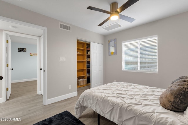 bedroom featuring a closet, ceiling fan, light wood-type flooring, and a spacious closet