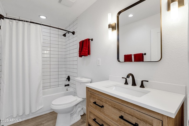 full bathroom with vanity, hardwood / wood-style floors, shower / bath combo with shower curtain, and toilet