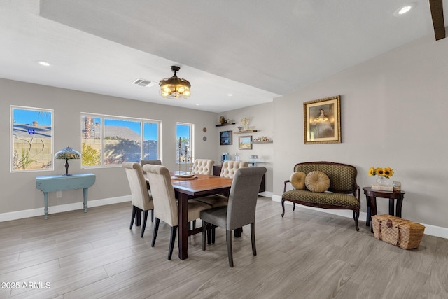 dining room with light wood-type flooring and lofted ceiling