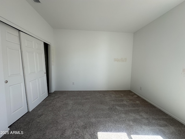 unfurnished bedroom with a closet, carpet flooring, and baseboards