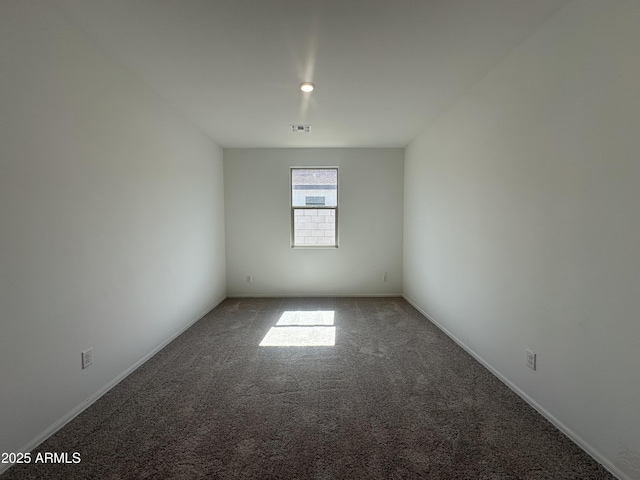 empty room with baseboards, visible vents, and carpet floors