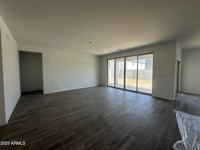 unfurnished living room featuring dark wood-style floors, baseboards, and visible vents
