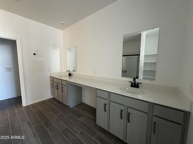 full bathroom featuring double vanity, wood finish floors, and a sink