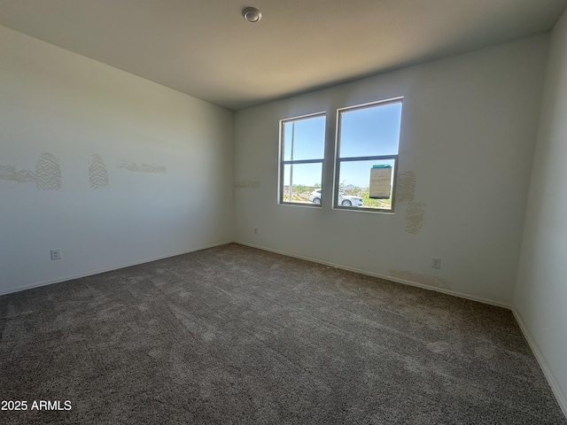 empty room with baseboards and carpet