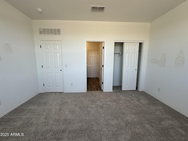 unfurnished bedroom with visible vents, a closet, carpet flooring, and baseboards