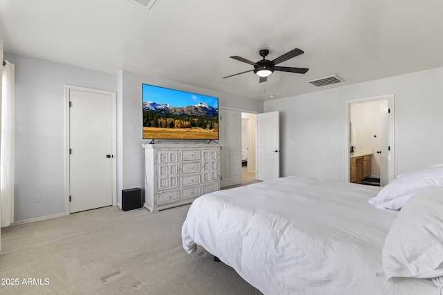 bedroom featuring ceiling fan, ensuite bath, and light carpet