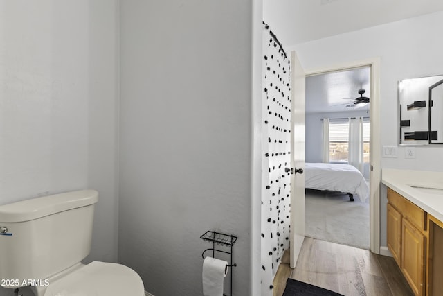 bathroom featuring vanity, ceiling fan, hardwood / wood-style flooring, and toilet