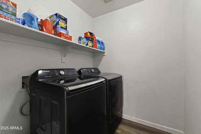 washroom featuring dark wood-type flooring and washing machine and dryer