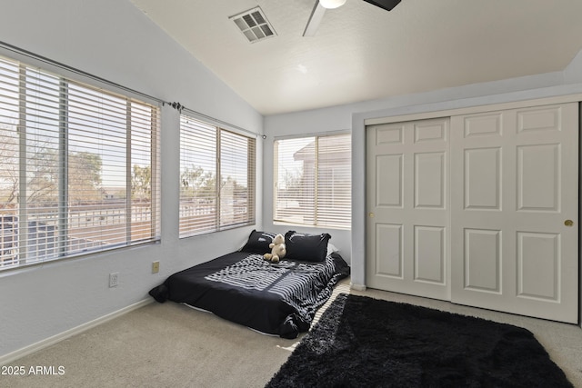 bedroom featuring ceiling fan, a closet, vaulted ceiling, and carpet