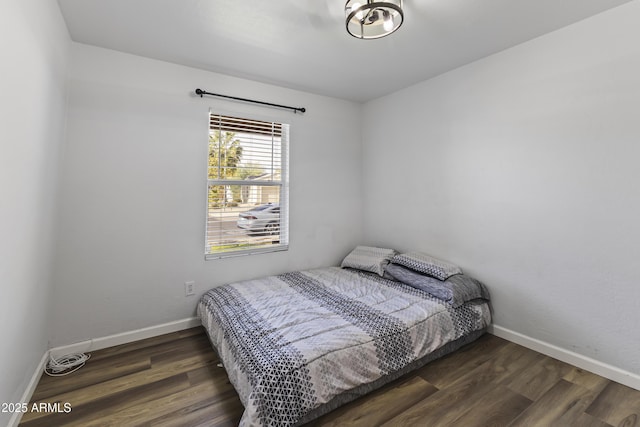 bedroom with dark hardwood / wood-style flooring