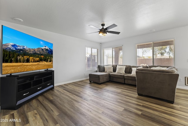 living room with dark hardwood / wood-style flooring and ceiling fan