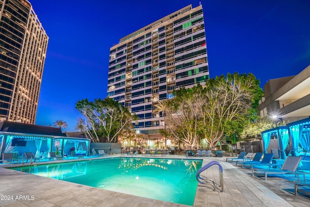 pool at twilight featuring a patio area