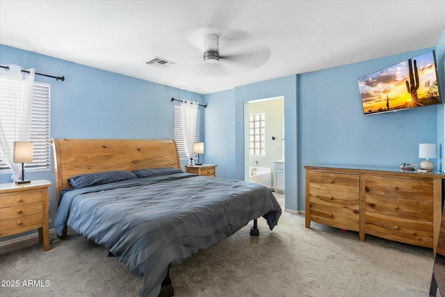 bedroom with visible vents, carpet, ensuite bathroom, and a ceiling fan