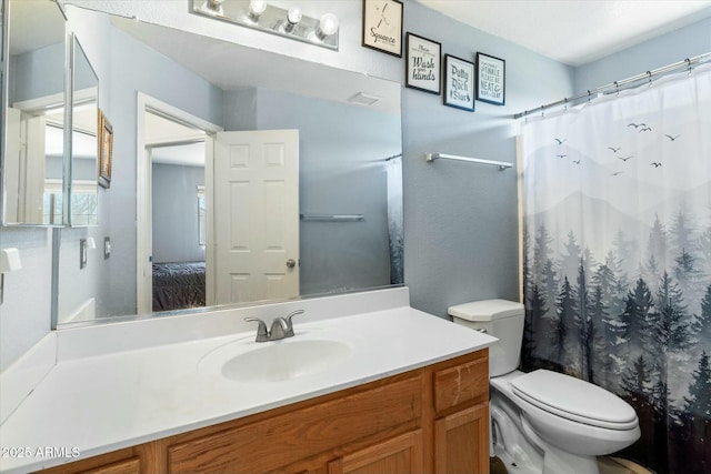 ensuite bathroom featuring vanity, toilet, a shower with curtain, and connected bathroom