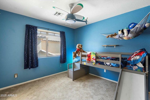 carpeted bedroom with visible vents, baseboards, and a ceiling fan