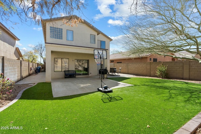 back of house featuring a fenced backyard, stucco siding, a lawn, and a patio