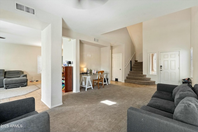 carpeted living room featuring visible vents and stairs