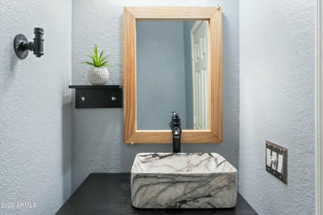 bathroom with a textured wall and a sink