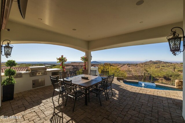 view of patio featuring area for grilling, pool water feature, and a mountain view