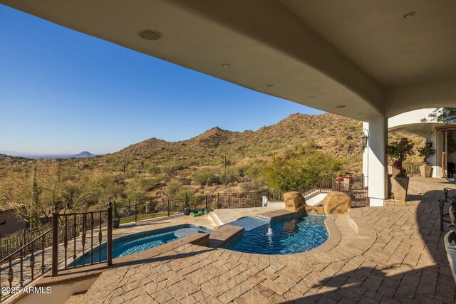 view of pool featuring a patio area, an in ground hot tub, and a mountain view