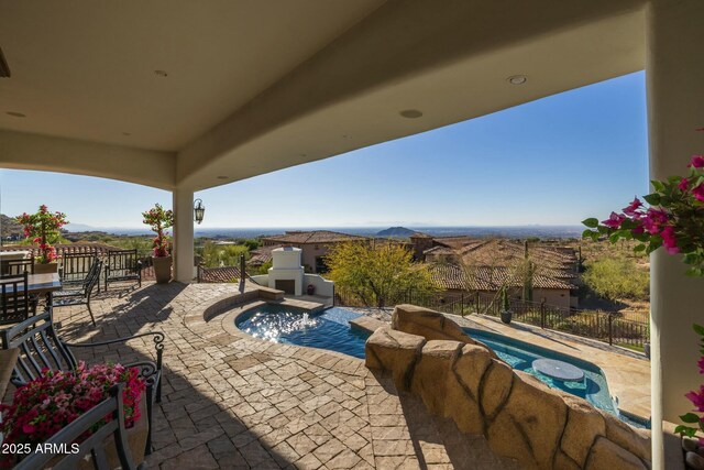 view of patio / terrace featuring a mountain view and an outdoor fireplace