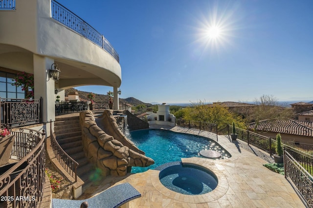 view of swimming pool with a patio area, an in ground hot tub, and a mountain view