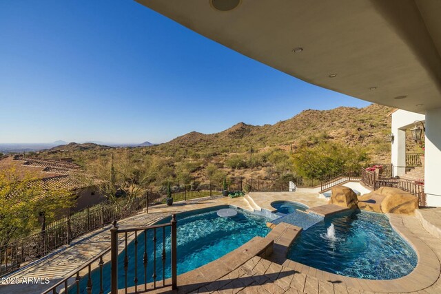 view of swimming pool with an in ground hot tub and a mountain view