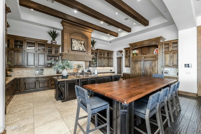 kitchen featuring a center island, dark brown cabinetry, backsplash, and paneled built in refrigerator