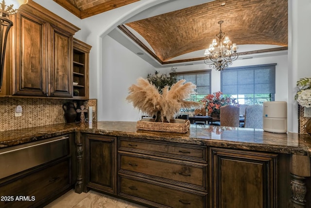 kitchen featuring brick ceiling, dark stone counters, lofted ceiling, and an inviting chandelier