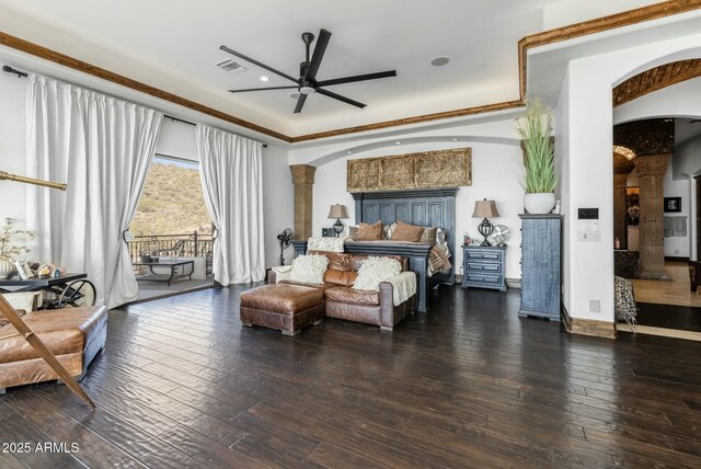 bedroom featuring hardwood / wood-style floors, ornate columns, and crown molding