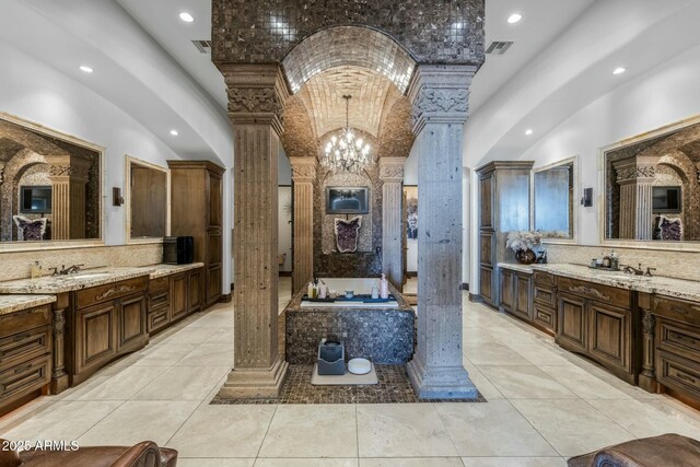 bathroom with ornate columns, a chandelier, lofted ceiling, brick ceiling, and vanity