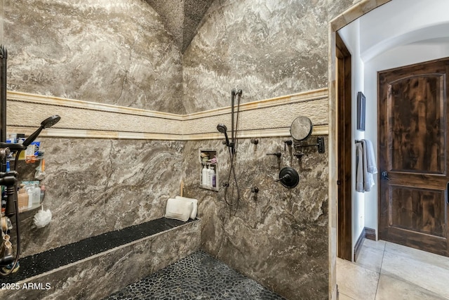 bathroom with a tile shower and vaulted ceiling