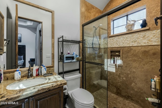 bathroom featuring lofted ceiling, toilet, a shower with door, and vanity