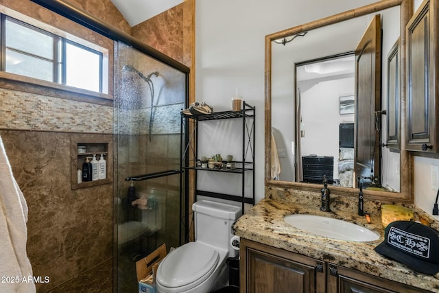 bathroom featuring vanity, toilet, a shower with shower door, and vaulted ceiling